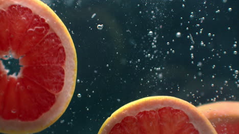 3-Grapefruitringe-Unter-Wasser-Mit-Luftblasen-Und-In-Zeitlupe.-Frischer-Und-Saftiger-Gesunder-Vegetarier